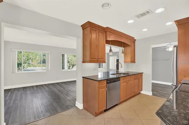 a kitchen with stainless steel appliances granite countertop a sink a stove and a wooden floors