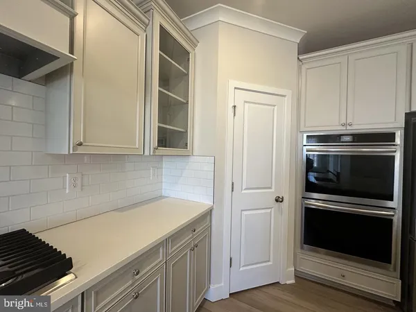 a kitchen with granite countertop white cabinets and stainless steel appliances