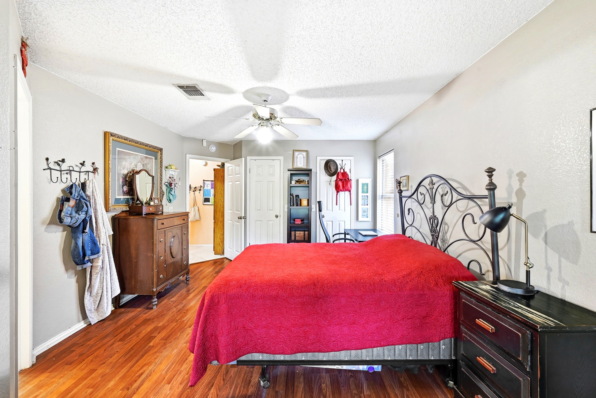 6412 Colton-Bluff Springs Road Austin, TX 78744 - Photo 15 of 27 Hardwood floors and a ceiling fan create a comfortable atmosphere in this well-appointed bedroom.