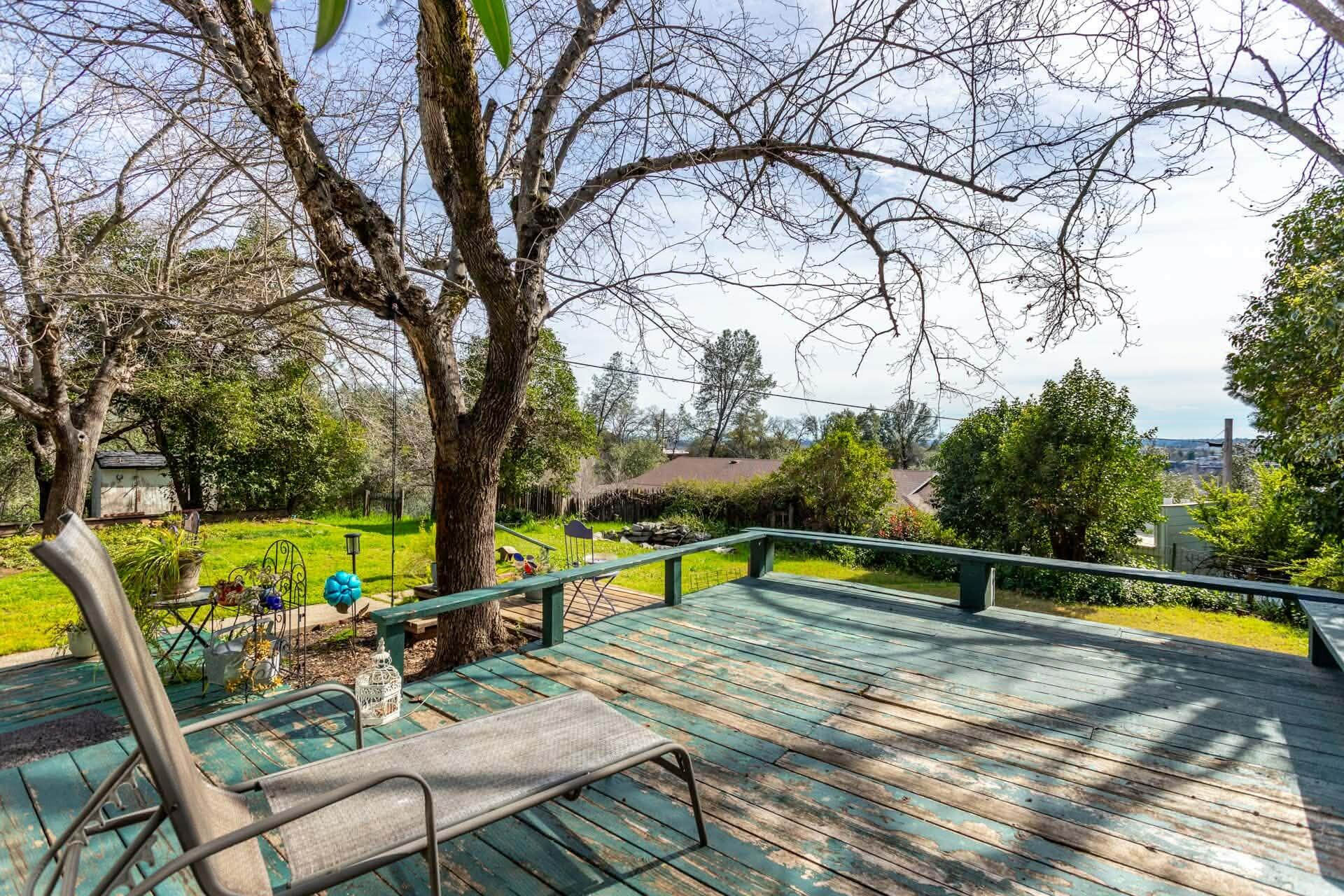 1715 Barbara Road Redding, CA 96003 - Photo 4 of 32 a view of a swimming pool with a bench and trees in the background