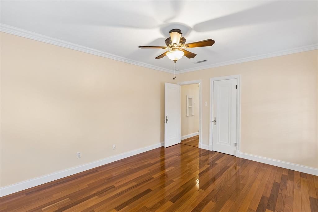 2427 Alco Avenue Dallas, TX 75211 - Photo 18 of 26 a view of an empty room with wooden floor and a ceiling fan