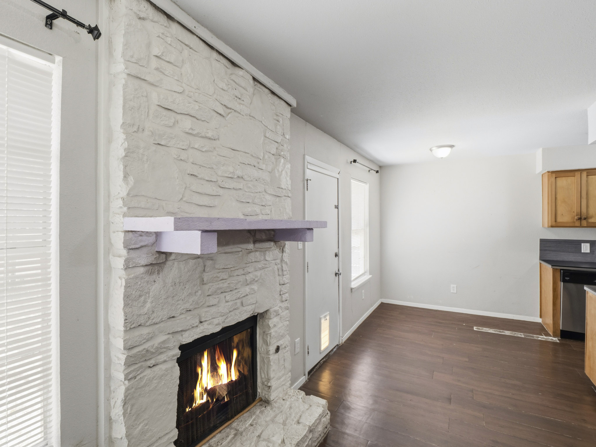 2401 Burleson Road Austin, TX 78741 - Photo 22 of 25 A striking stone fireplace warms the open-concept living space with rich wood flooring.