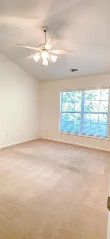 an empty room with windows and chandelier fan