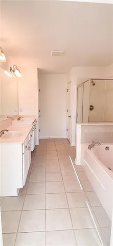 a large white kitchen with a sink and chandelier