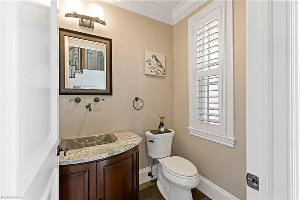 a bathroom with a granite countertop toilet sink and mirror