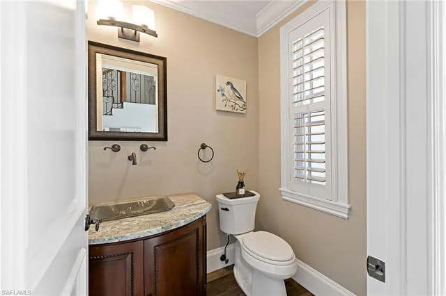 a bathroom with a granite countertop toilet sink and mirror