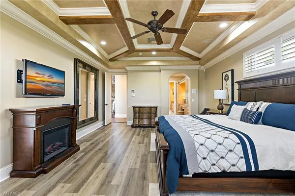 a spacious bedroom with a balcony a bed and a television with the dresser