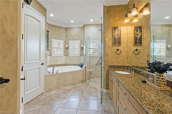 a spacious bathroom with a tub sink shower and mirror