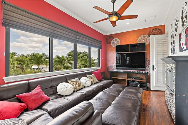 a living room with furniture a flat screen tv and a large window