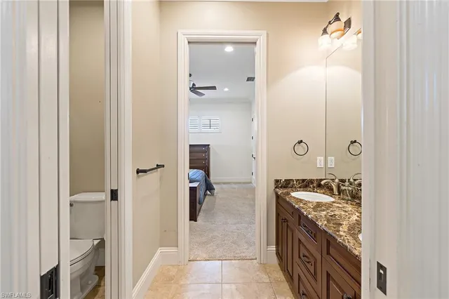 a spacious bathroom with a granite countertop sink a mirror and shower