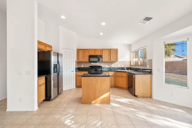 a kitchen with granite countertop a stove sink and cabinets
