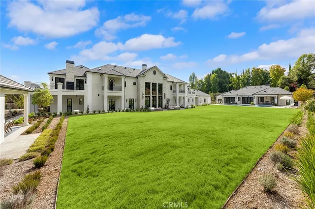 a view of a house with a big yard and large trees