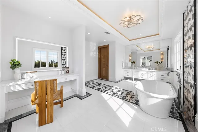 a spacious bathroom with a tub double sink and glass door