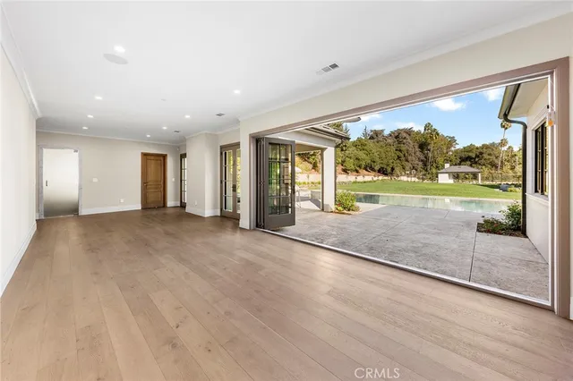 a view of an empty room with glass door and windows