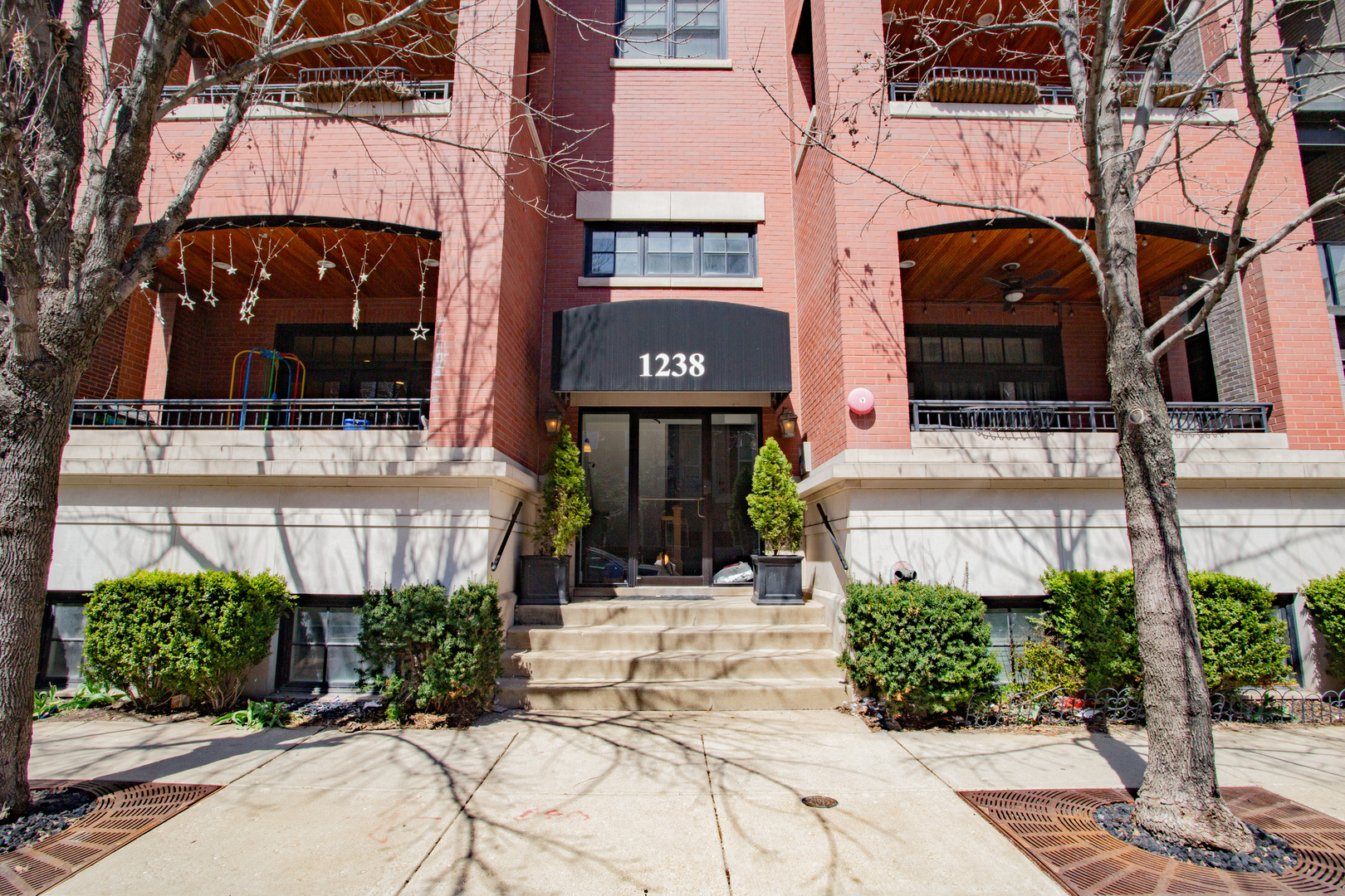 1238 West Jackson Boulevard, Unit 3W Chicago, IL 60607 - Photo 2 of 23 a view of building with a street sign and potted plants