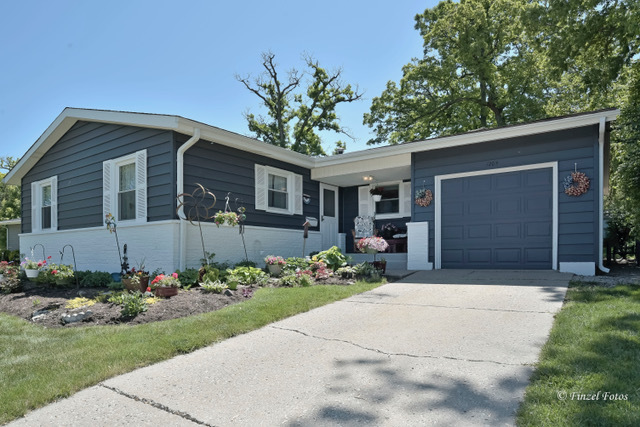 a front view of a house with a garden and yard