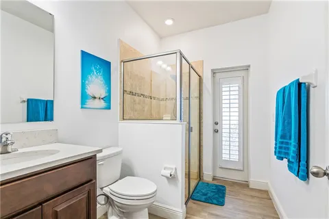 an empty room with wooden floor closet and windows