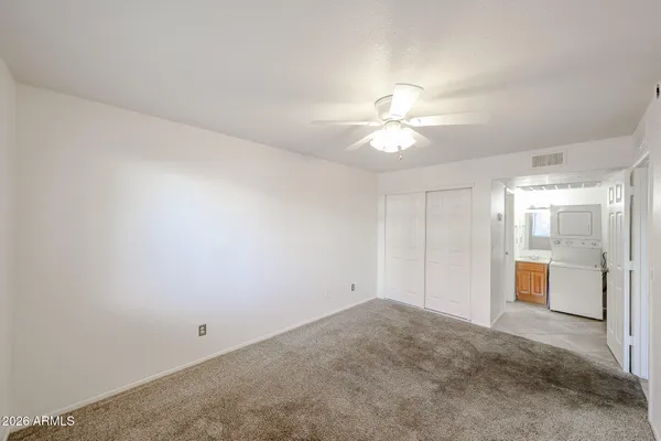 an empty room with a ceiling fan and a window