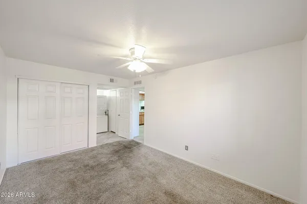 an empty room with a window and a ceiling fan