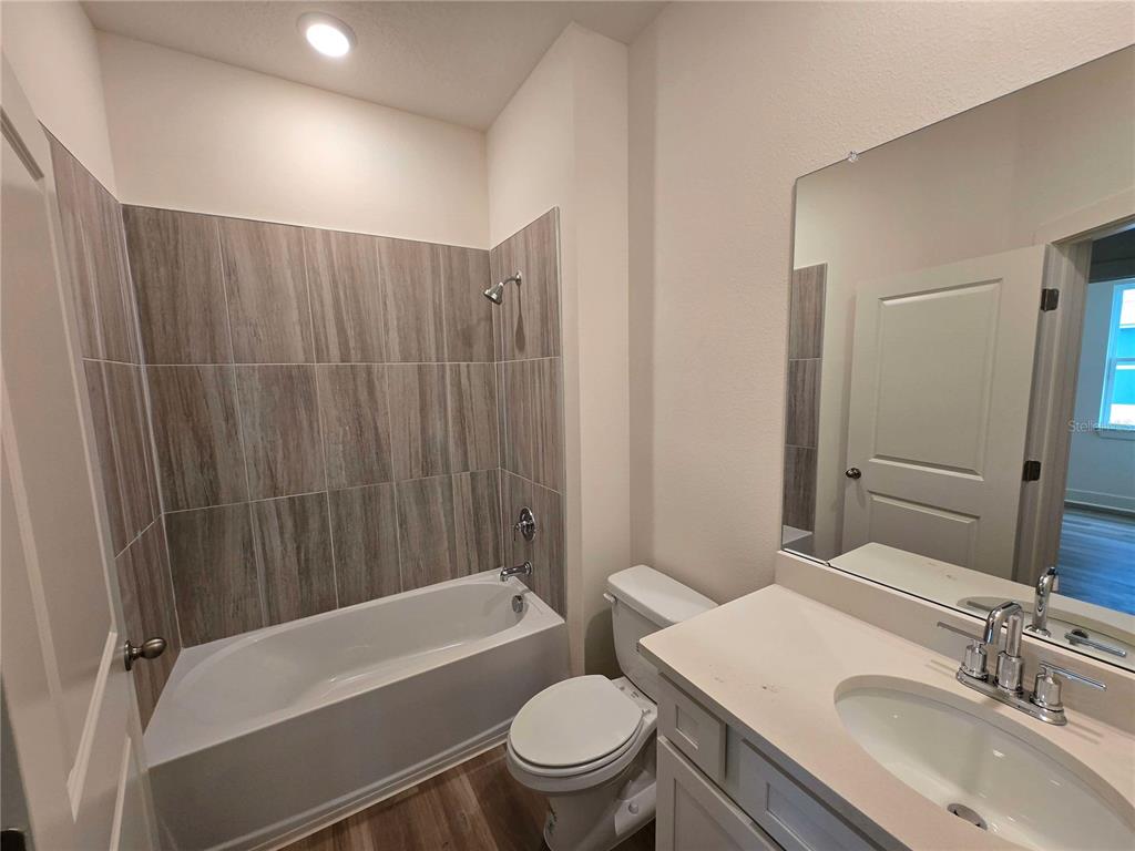 3836 Daybreak Run Loop Spring Hill, FL 34609 - Photo 11 of 13 a bathroom with a sink a toilet a mirror a bathtub and shower