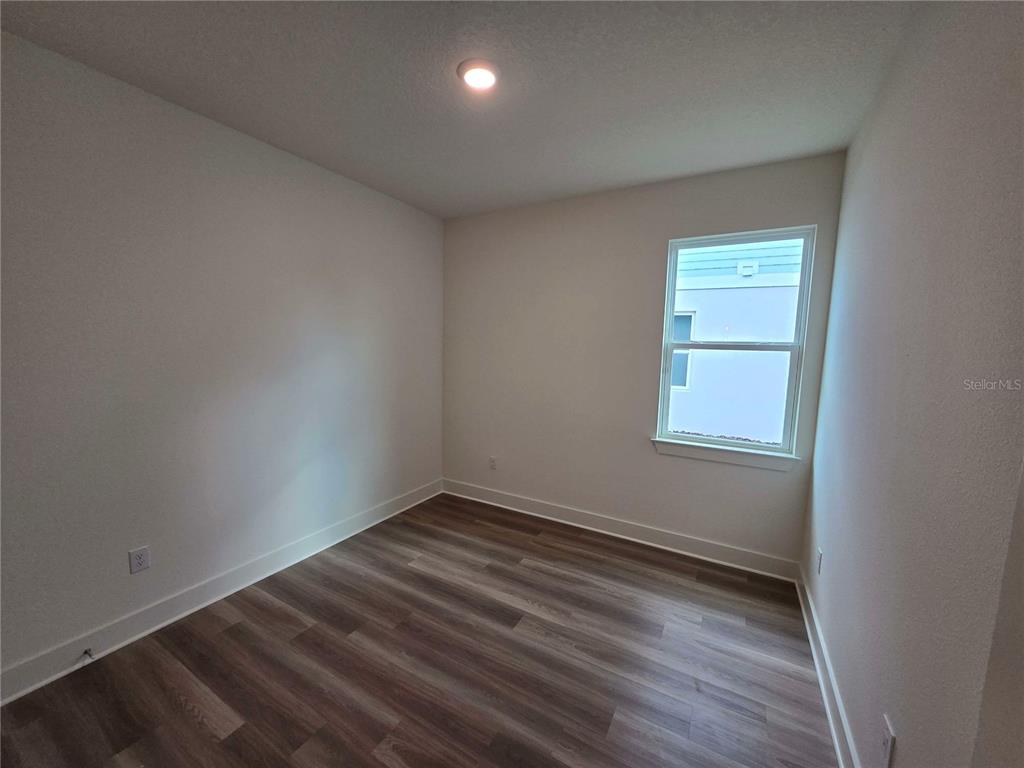 3836 Daybreak Run Loop Spring Hill, FL 34609 - Photo 12 of 13 an empty room with wooden floor and windows