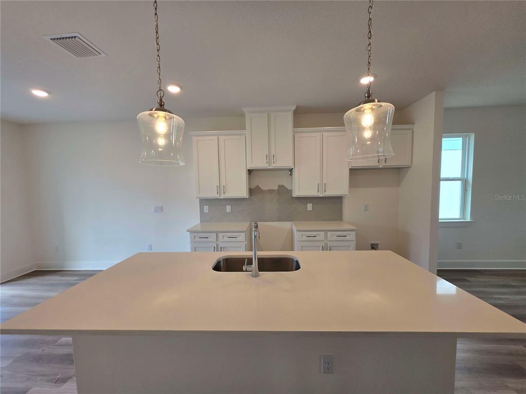 3836 Daybreak Run Loop Spring Hill, FL 34609 - Photo 4 of 13 a kitchen with kitchen island a stove a sink and a table