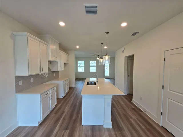 a large kitchen with stainless steel appliances a large counter top a stove and a refrigerator