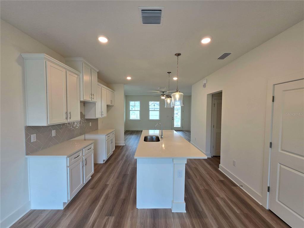 3836 Daybreak Run Loop Spring Hill, FL 34609 - Photo 5 of 13 a large kitchen with stainless steel appliances a large counter top a stove and a refrigerator