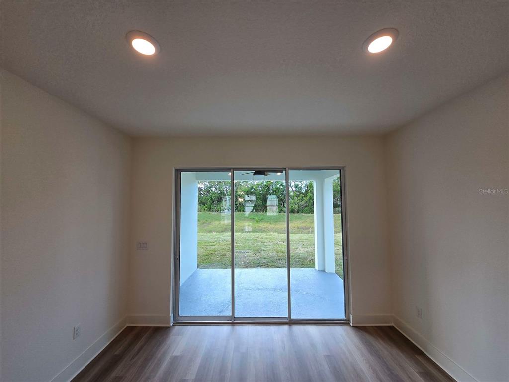 3836 Daybreak Run Loop Spring Hill, FL 34609 - Photo 6 of 13 wooden floor in an empty room with a window