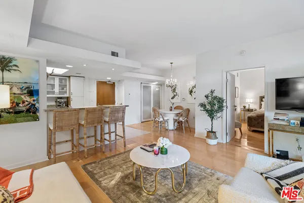 a living room with furniture and a dining table with kitchen view