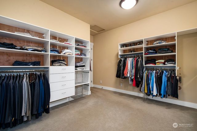 a view of walk in closet with clothes and shoes