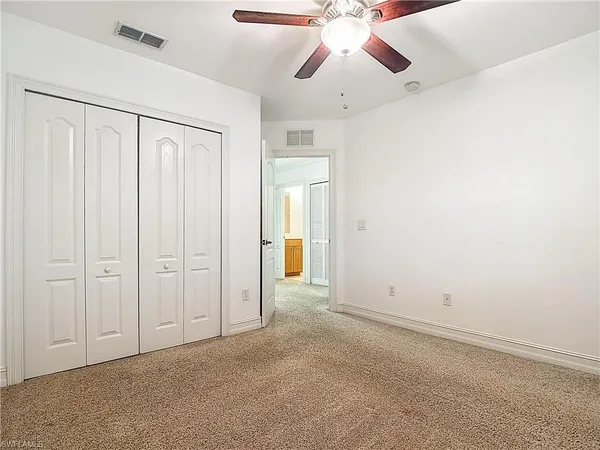 an empty room with chandelier fan