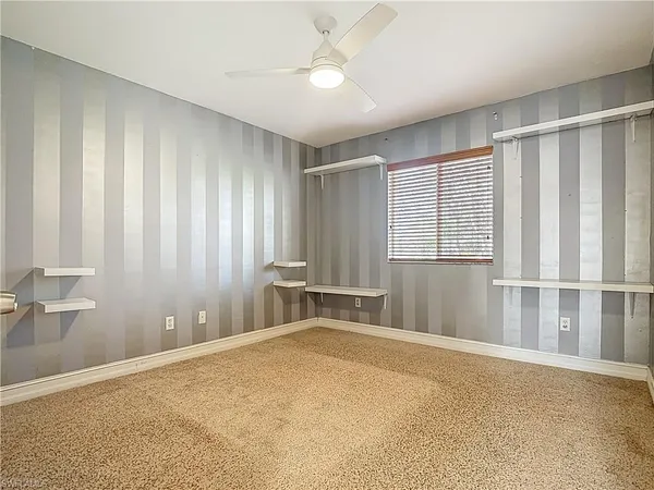 a view of an empty room with a cabinet and a window