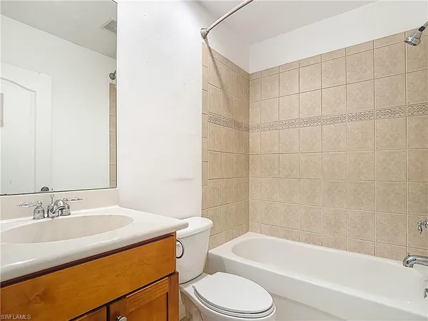 a bathroom with a tub sink and mirror