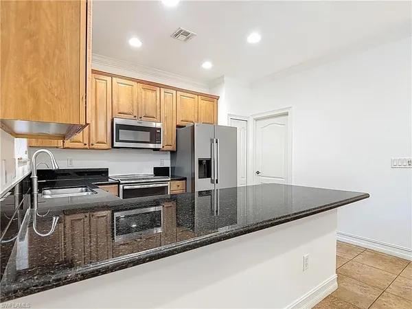 a kitchen with stainless steel appliances granite countertop a refrigerator sink and stove