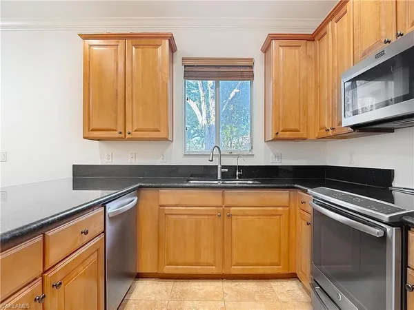 a kitchen with stainless steel appliances granite countertop a stove a sink and a microwave