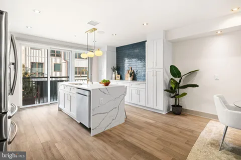 a living room with furniture a dining table a lamp and potted plants