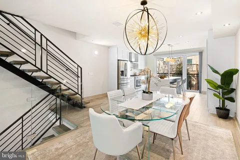 a dining room with livingroom view and wooden floor