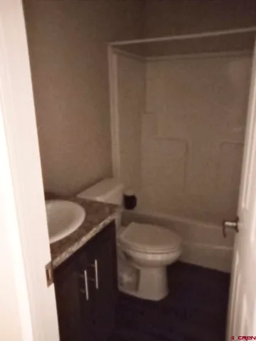 a bathroom with a granite countertop toilet and a sink
