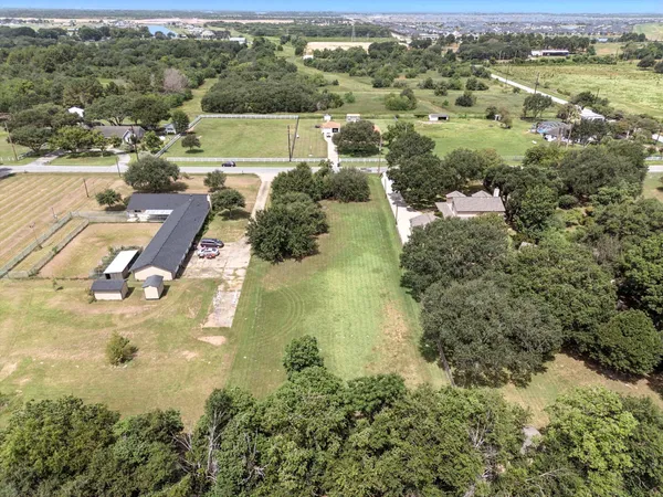an aerial view of residential houses with outdoor space and trees