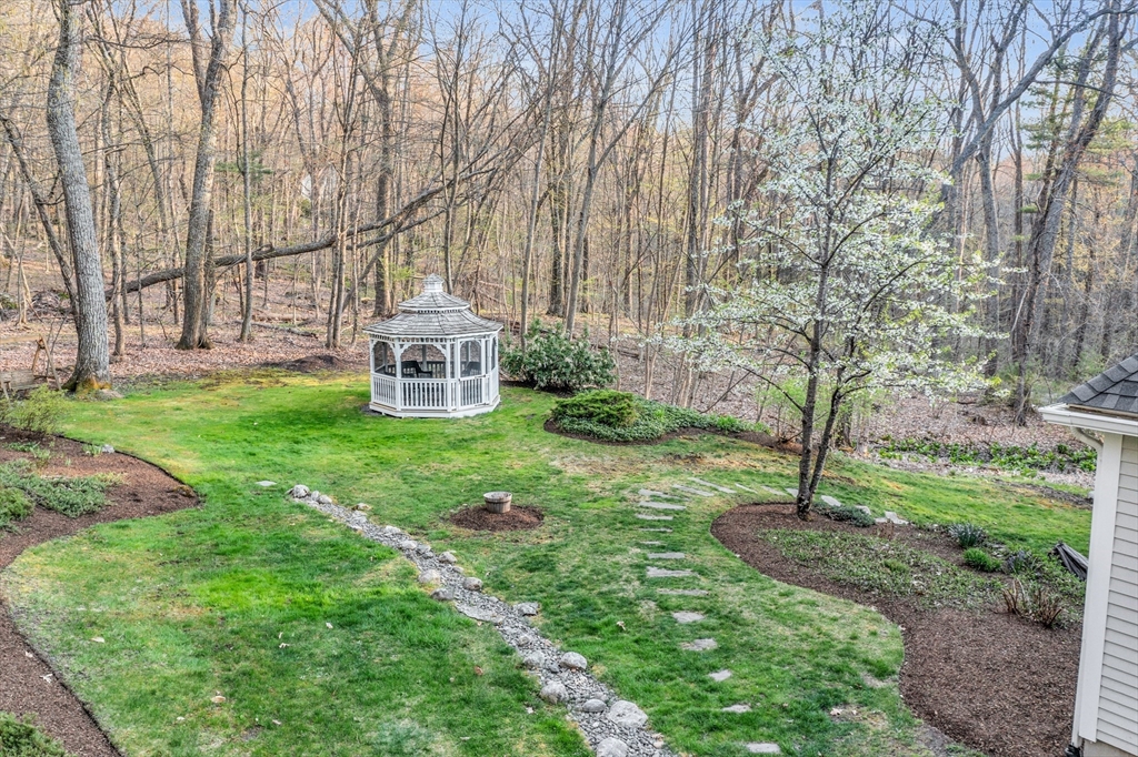 133 Nashaway Road Bolton, MA 01740 - Photo 38 of 42 a white house with a yard and large trees