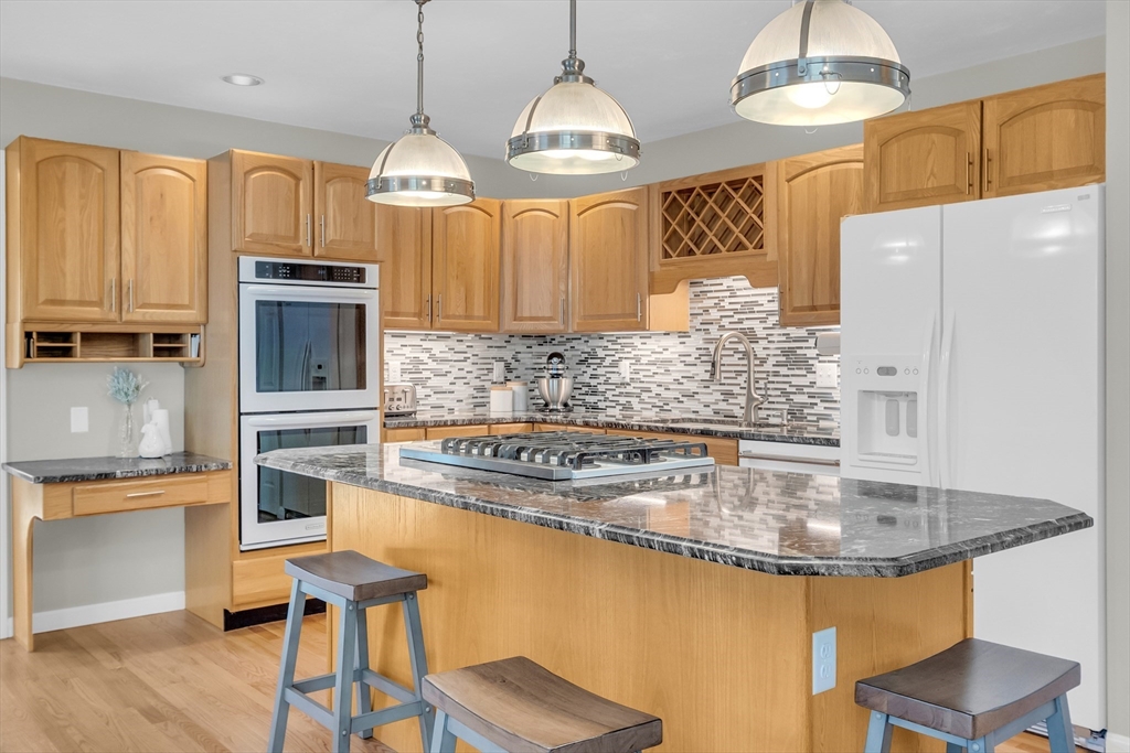 133 Nashaway Road Bolton, MA 01740 - Photo 9 of 42 a kitchen with stainless steel appliances granite countertop a sink a stove and a refrigerator