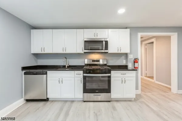 a kitchen with stainless steel appliances granite countertop a stove a sink and a microwave