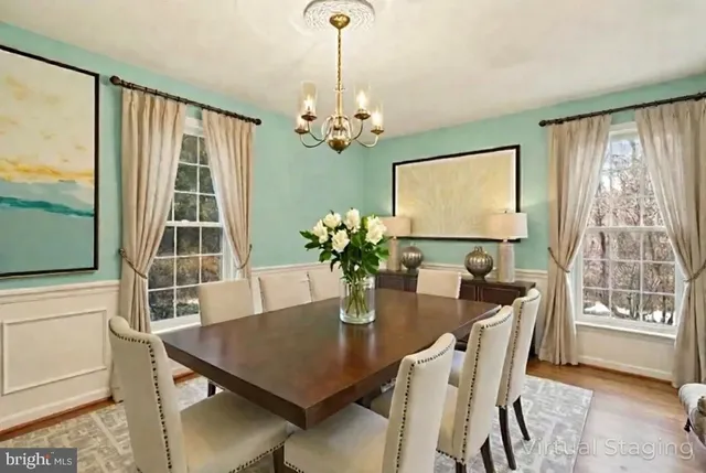 a view of an empty room with window and chandelier fan