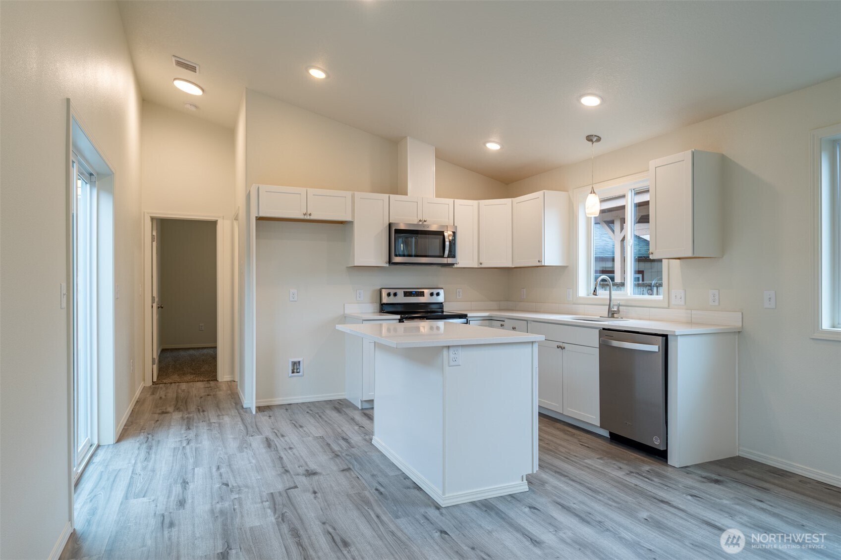 569 North 3rd Kalama, WA 98625 - Photo 10 of 22 a kitchen with kitchen island wooden floors appliances and cabinets