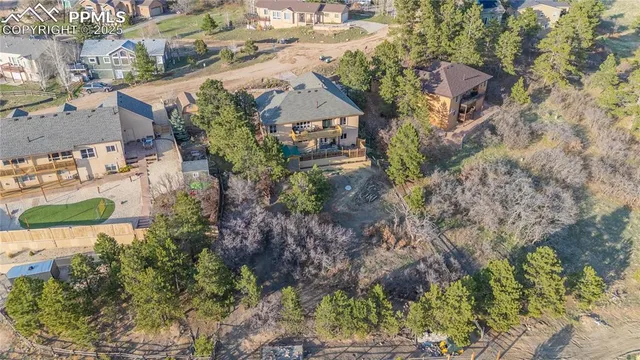 an aerial view of a house with a yard and a large tree