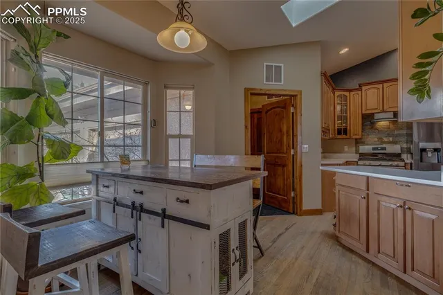 a kitchen with stainless steel appliances granite countertop a kitchen island a stove and a refrigerator