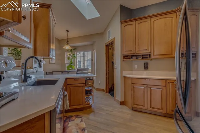 a kitchen with stainless steel appliances a sink cabinets and wooden floor