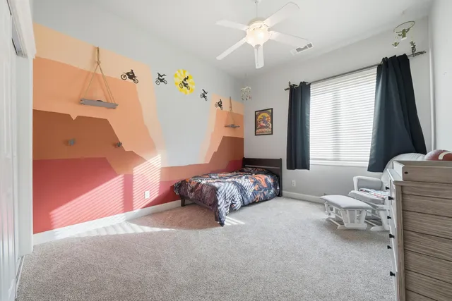 a spacious bedroom with a bed couch and window
