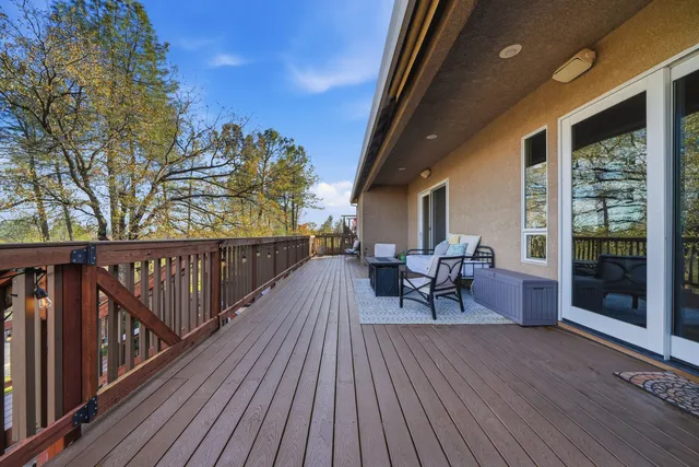 a view of a patio with table and chairs with wooden floor and fence